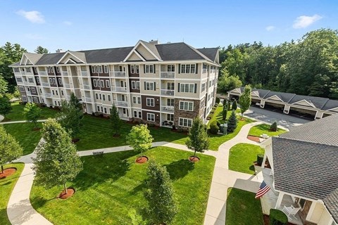 an aerial view of an apartment building with lawns and trees