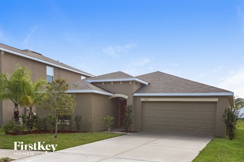 a beige house with a driveway and a garage door