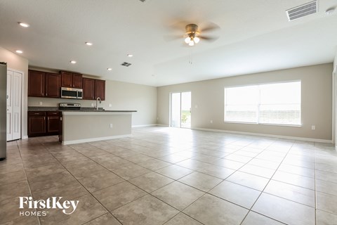an empty kitchen and living room with a ceiling fan