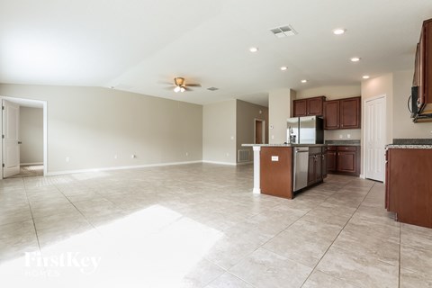 a kitchen and living room with tile flooring and wooden cabinets