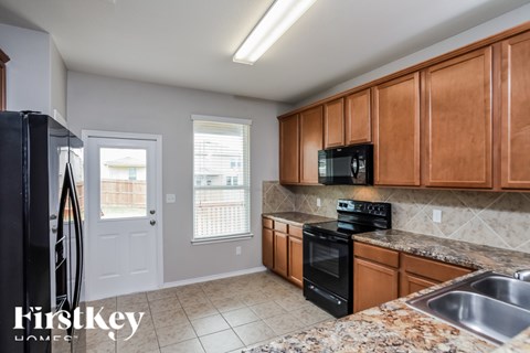 A kitchen with wooden cabinets and a black stove top oven.