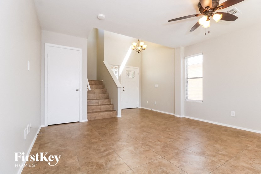 A spacious room with a staircase leading to the second floor.