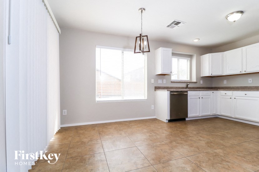 A kitchen with white cabinets and a tiled floor.