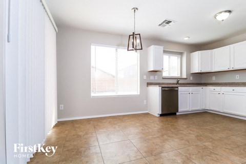 A kitchen with white cabinets and a tiled floor.