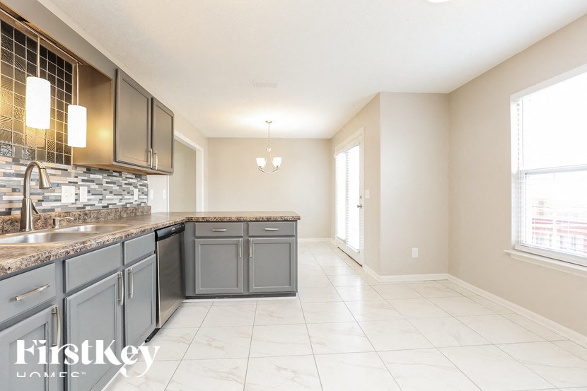 A kitchen with a tile backsplash and a sink.