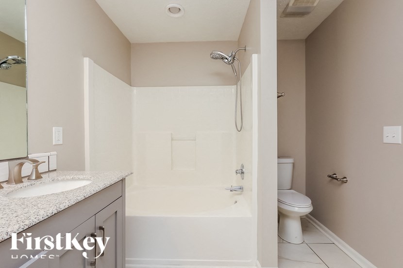 A bathroom with a toilet, sink, and shower.