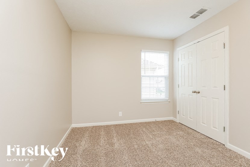 A room with a carpeted floor and a door.