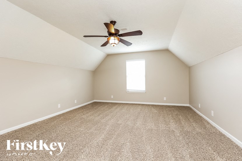 A room with a ceiling fan and a window.