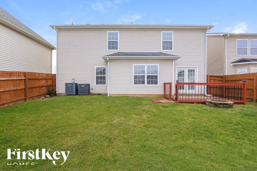 A house with a fence and a green trash can is for sale.