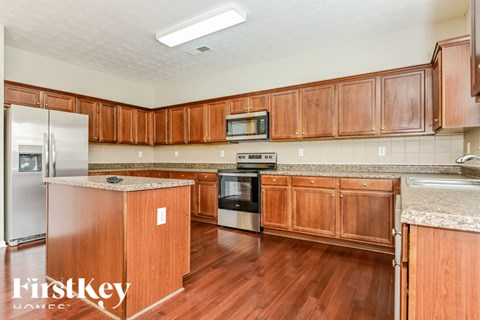 A kitchen with wooden cabinets and a refrigerator.