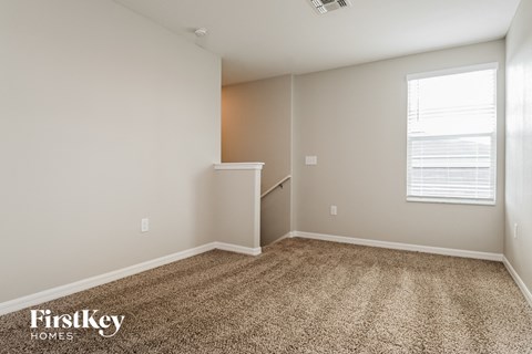 an empty room with carpet and a window