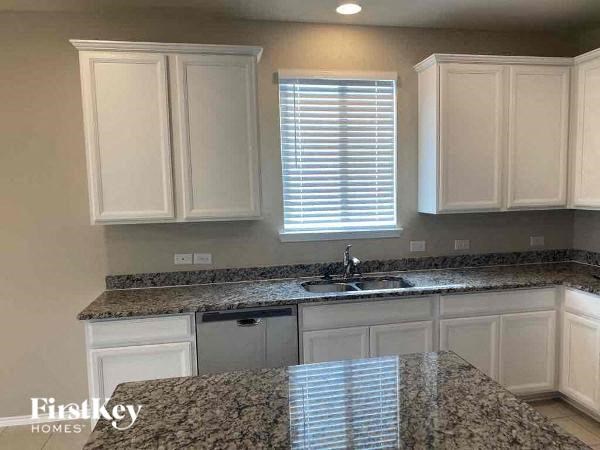 A kitchen with granite countertops and white cabinets.