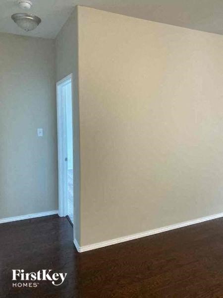 A room with a white wall and a wooden floor.