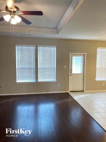 A room with a ceiling fan and a door.