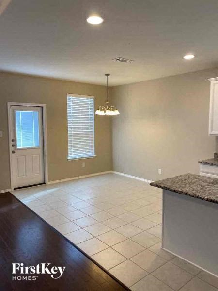 A spacious kitchen and living room area with a white door and window.