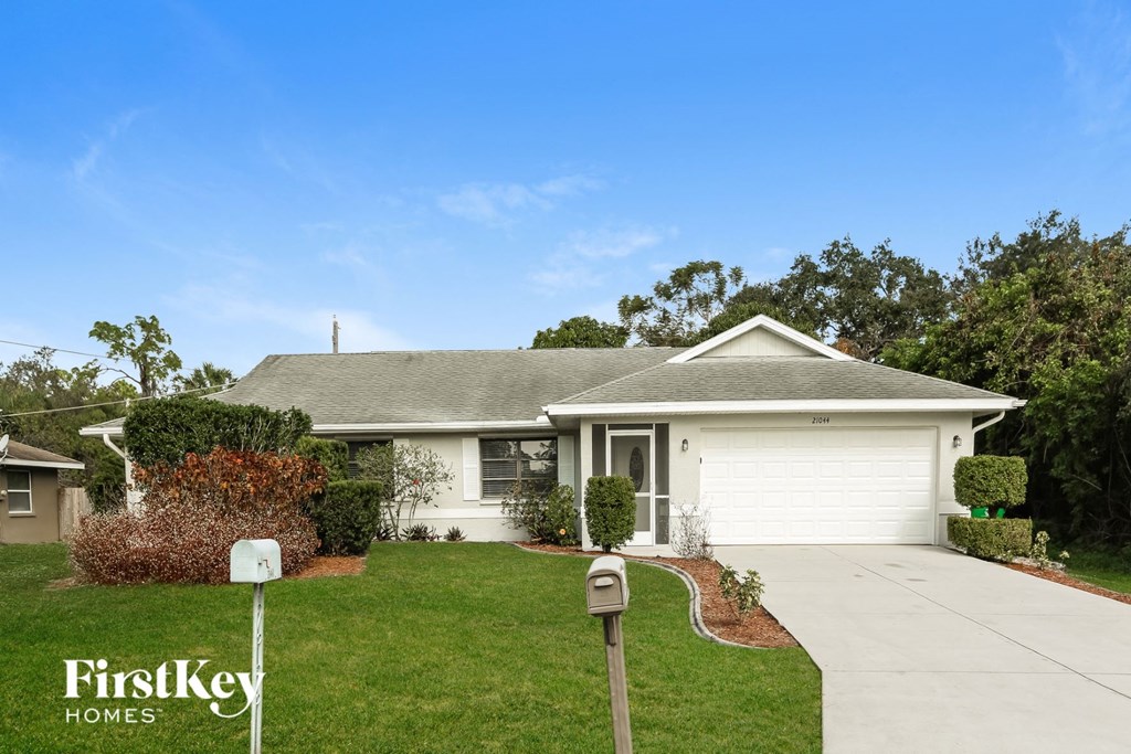 a white house with a yard and a parking meter