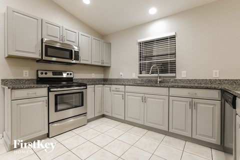 a kitchen with white cabinets and stainless steel appliances