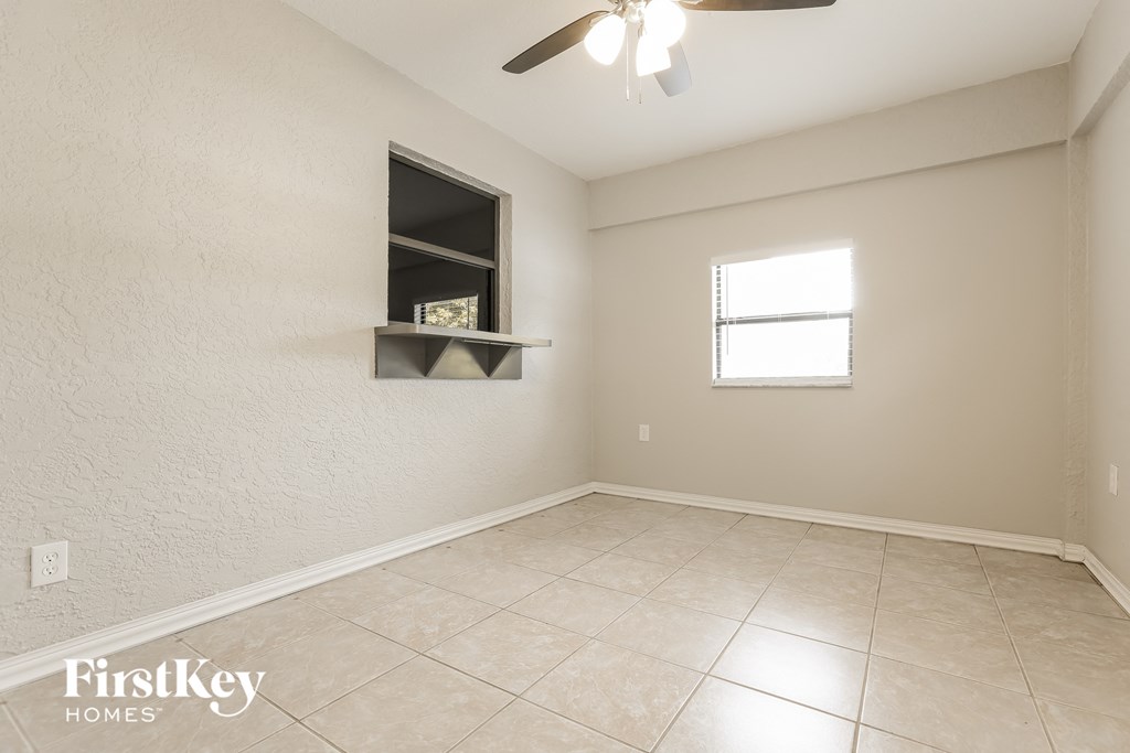 an empty room with a ceiling fan and a window