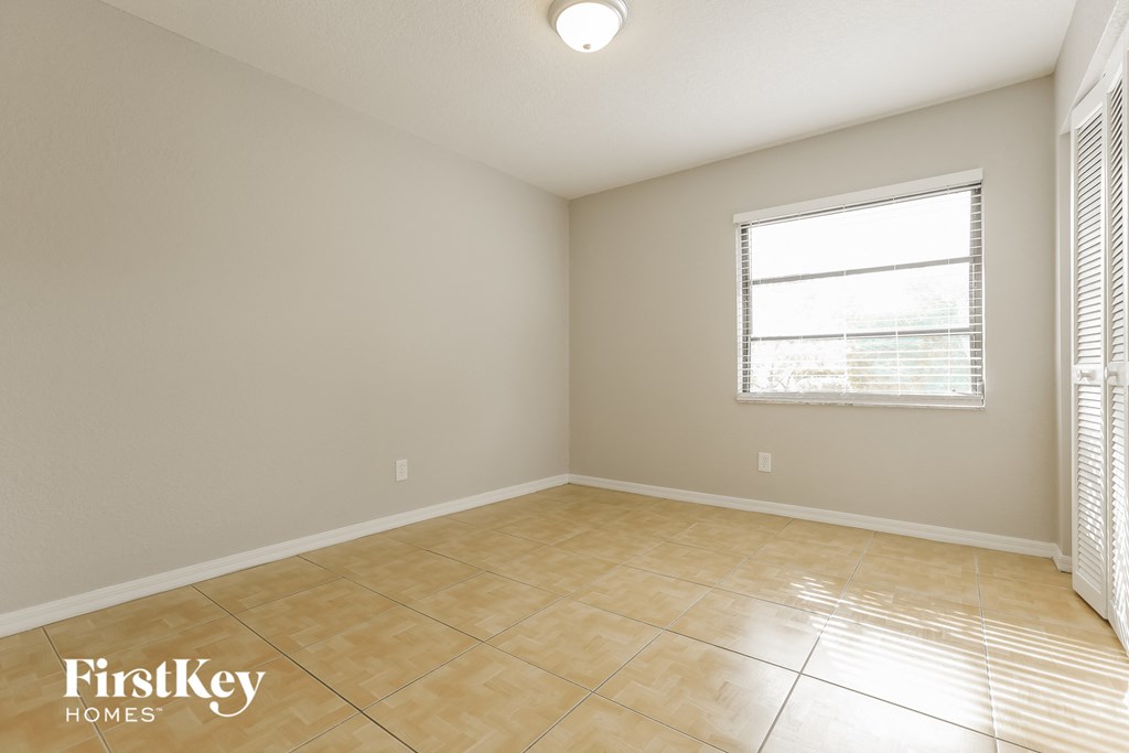 the spacious living room has a large window and tiled floors