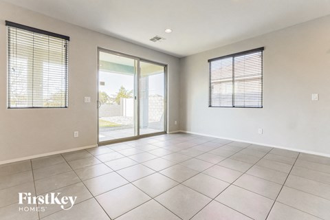 an empty living room with sliding glass doors to a patio