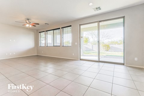 an empty living room with sliding glass doors to a patio