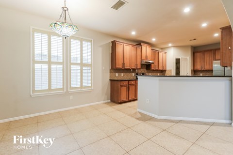 A kitchen with wooden cabinets and a tiled floor.