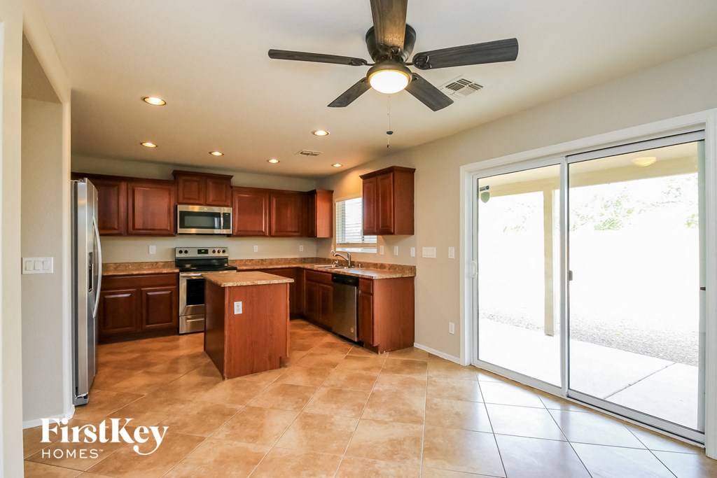 a kitchen with wooden cabinets and a ceiling fan