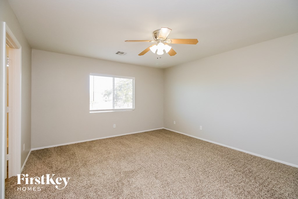 a bedroom with carpet and a ceiling fan