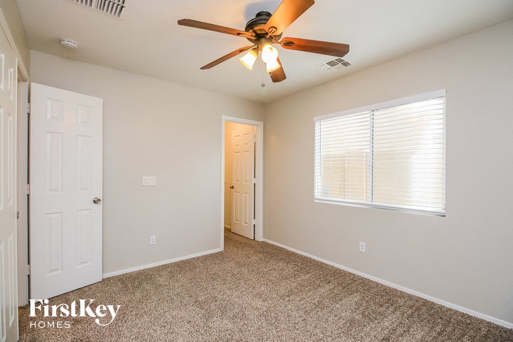 a bedroom with a ceiling fan and a door to a closet