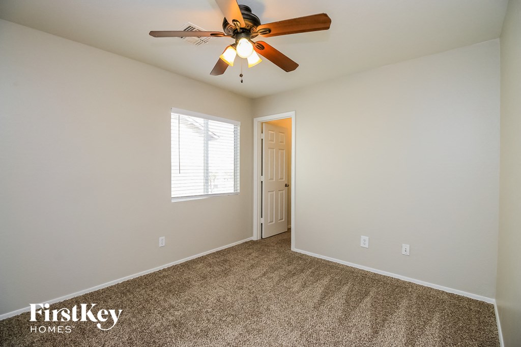 the master bedroom has a ceiling fan and carpeted flooring