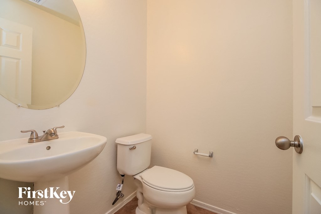a bathroom with a toilet and a sink and a mirror