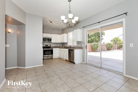 A kitchen with a dining table and chairs is shown.