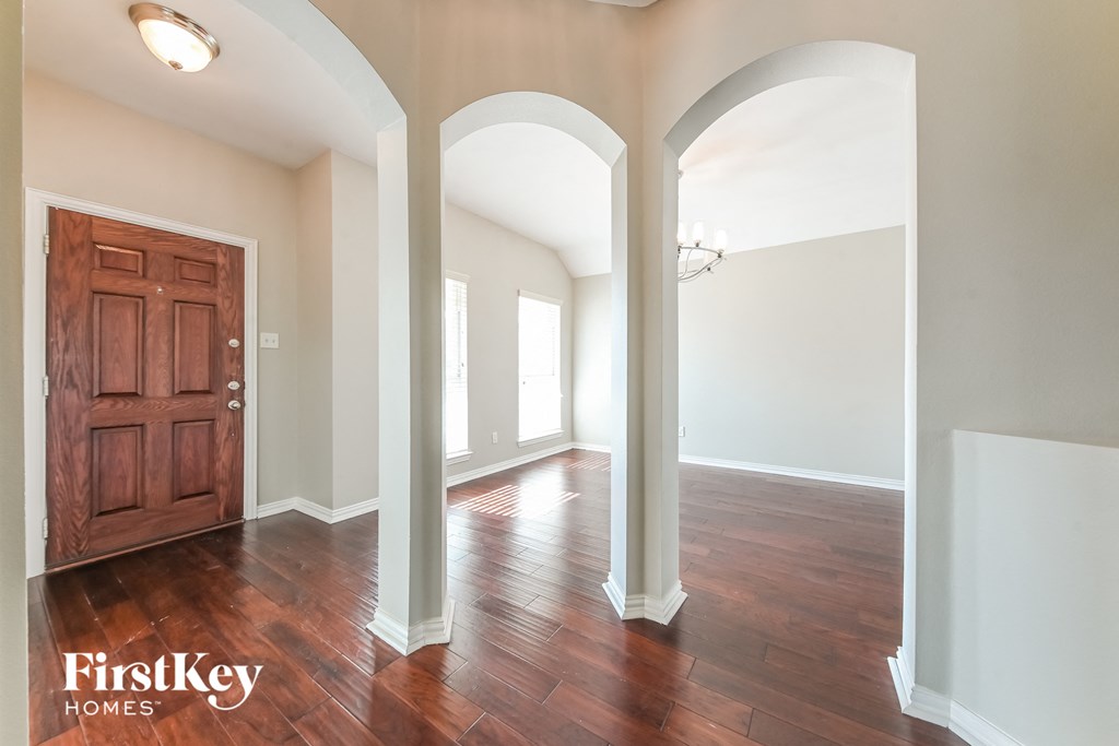 A room with a wooden door and arched columns.