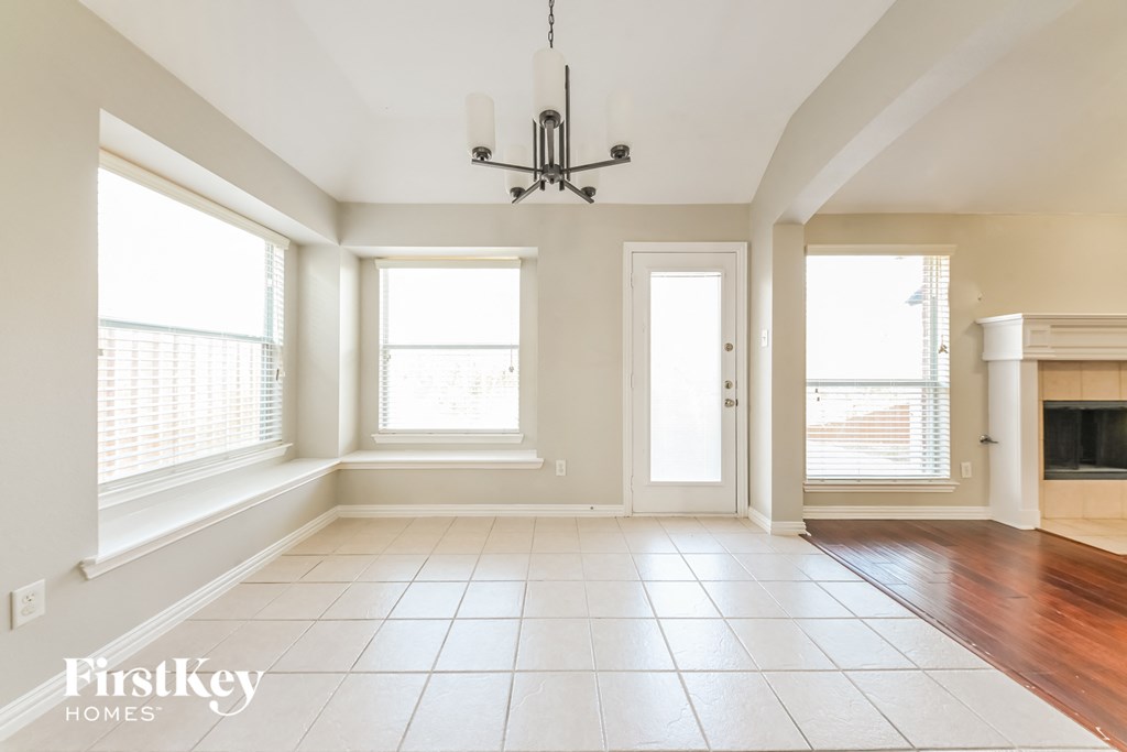A spacious room with a chandelier and a fireplace.