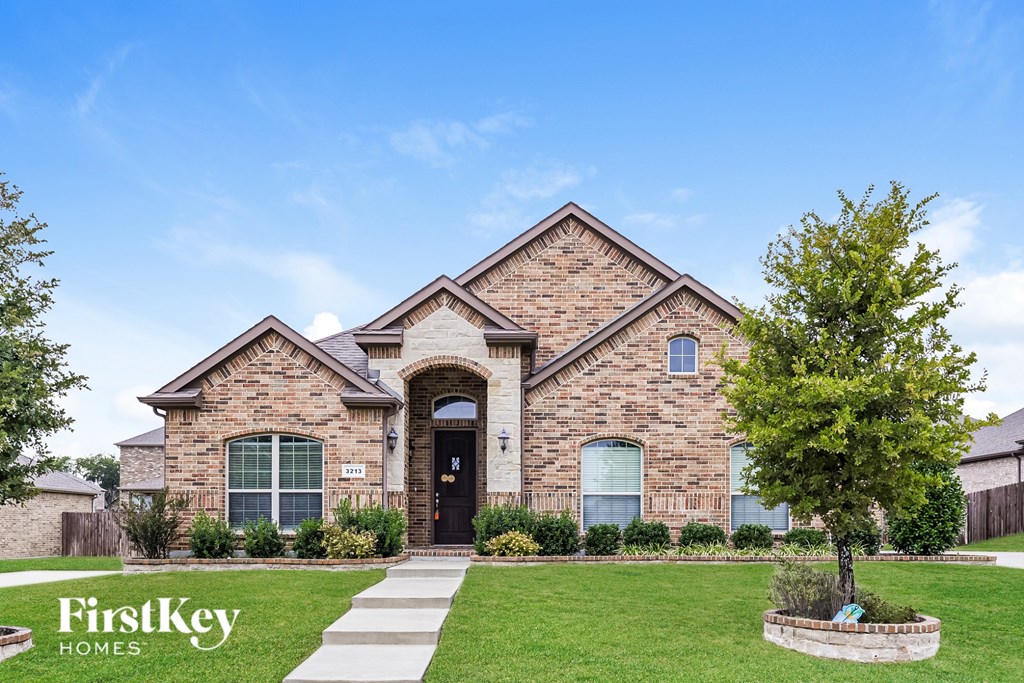 A brick house with a tree in front of it.