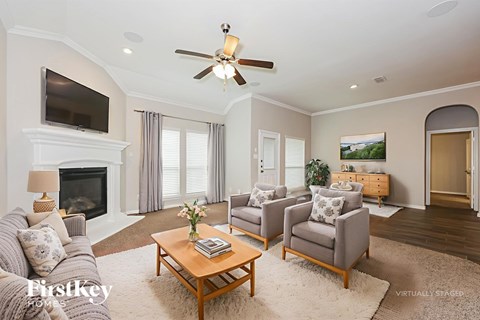 A living room with a fireplace and a television on the wall.