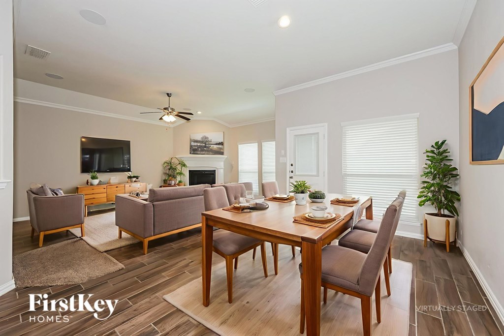 A well-lit living room with a dining table and chairs.