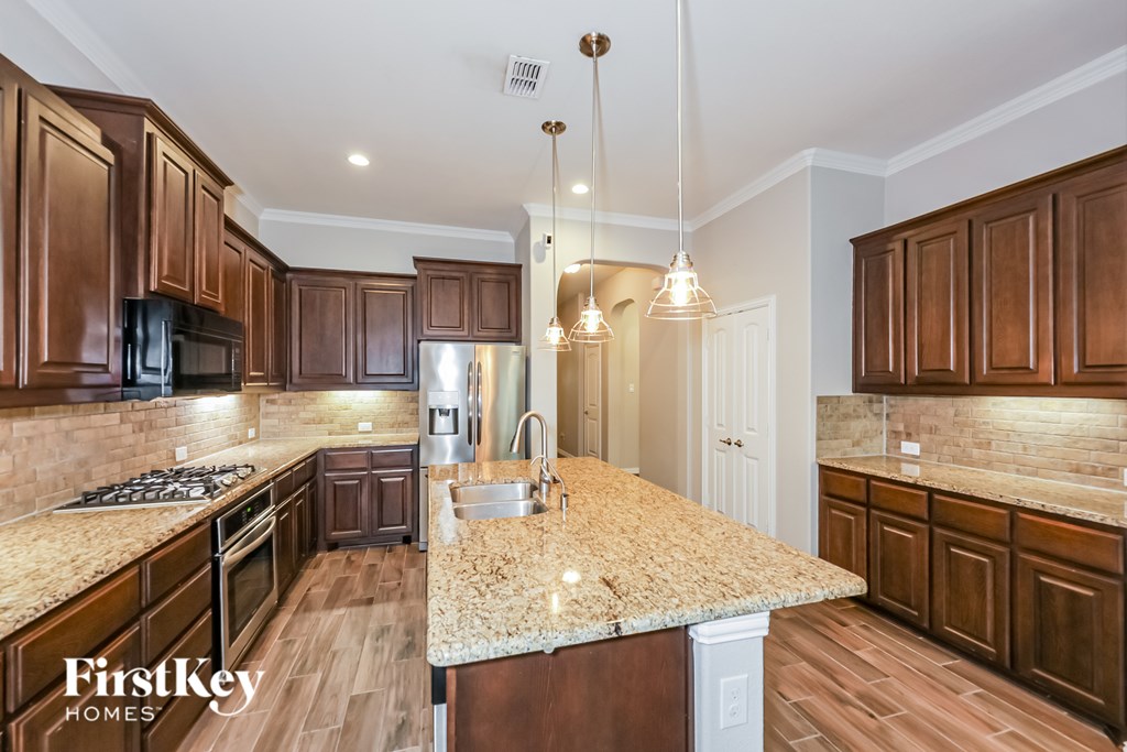 A kitchen with brown cabinets and a granite countertop.