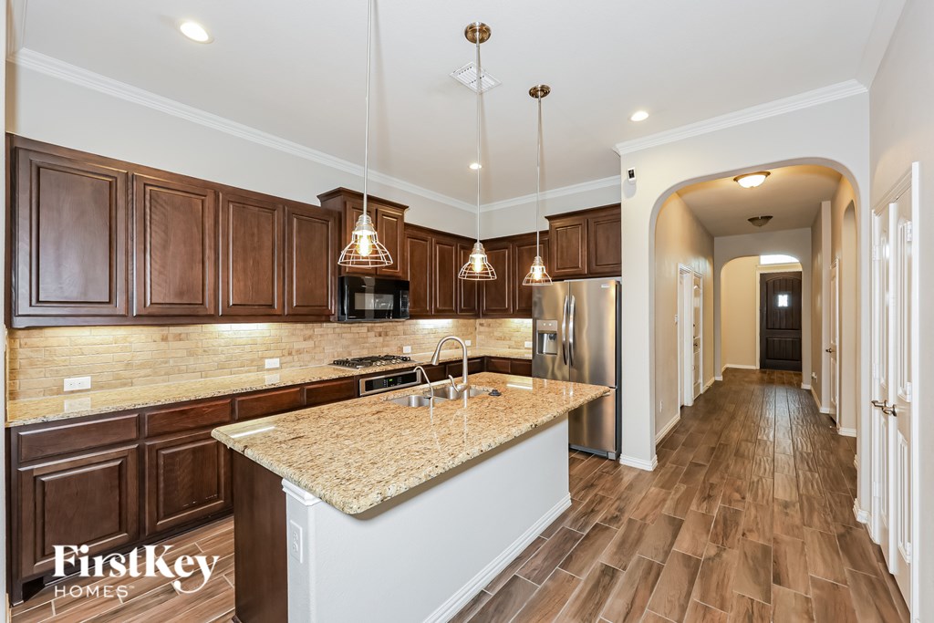 A kitchen with wooden cabinets and a granite countertop.