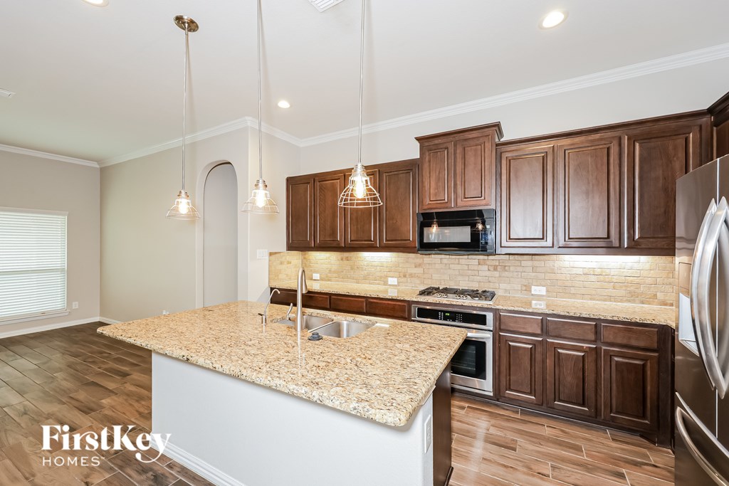 A kitchen with wooden cabinets and a granite countertop.