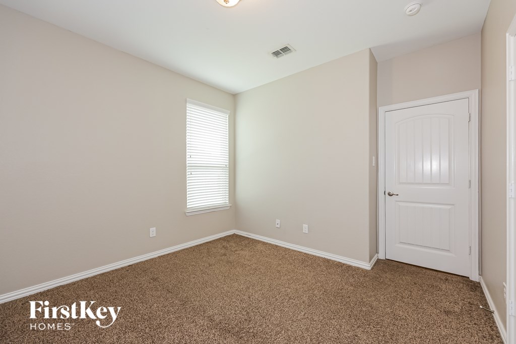 A room with a carpeted floor and a white door.