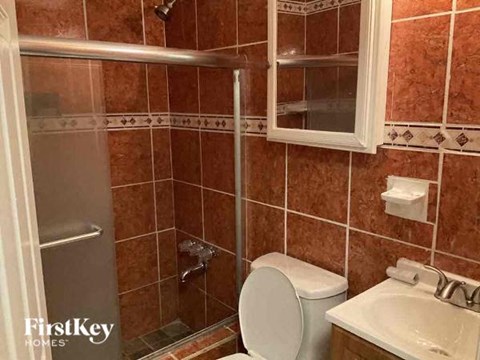 a bathroom with a toilet and a sink and a shower