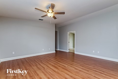 a living room with wood floors and a ceiling fan