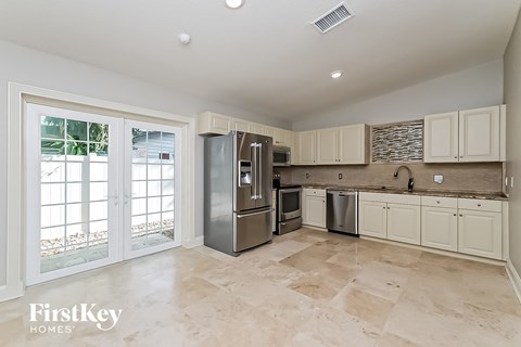 a large kitchen with stainless steel appliances and white cabinets