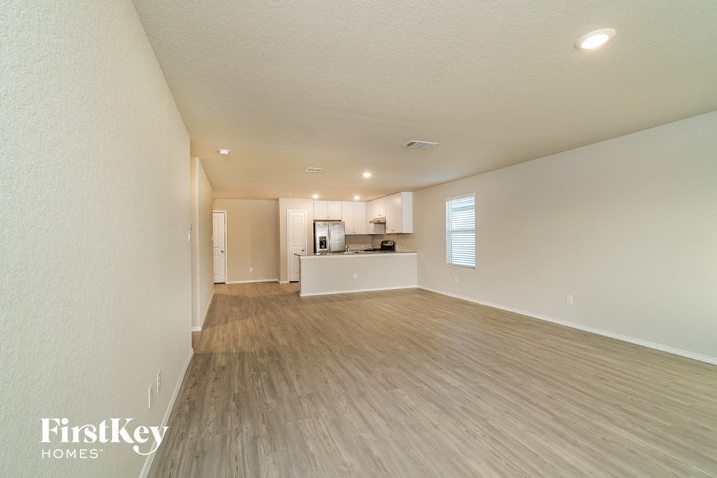 the living room and kitchen of an apartment with wood flooring