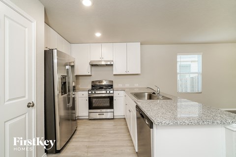 a kitchen with white cabinets and stainless steel appliances and a granite counter top