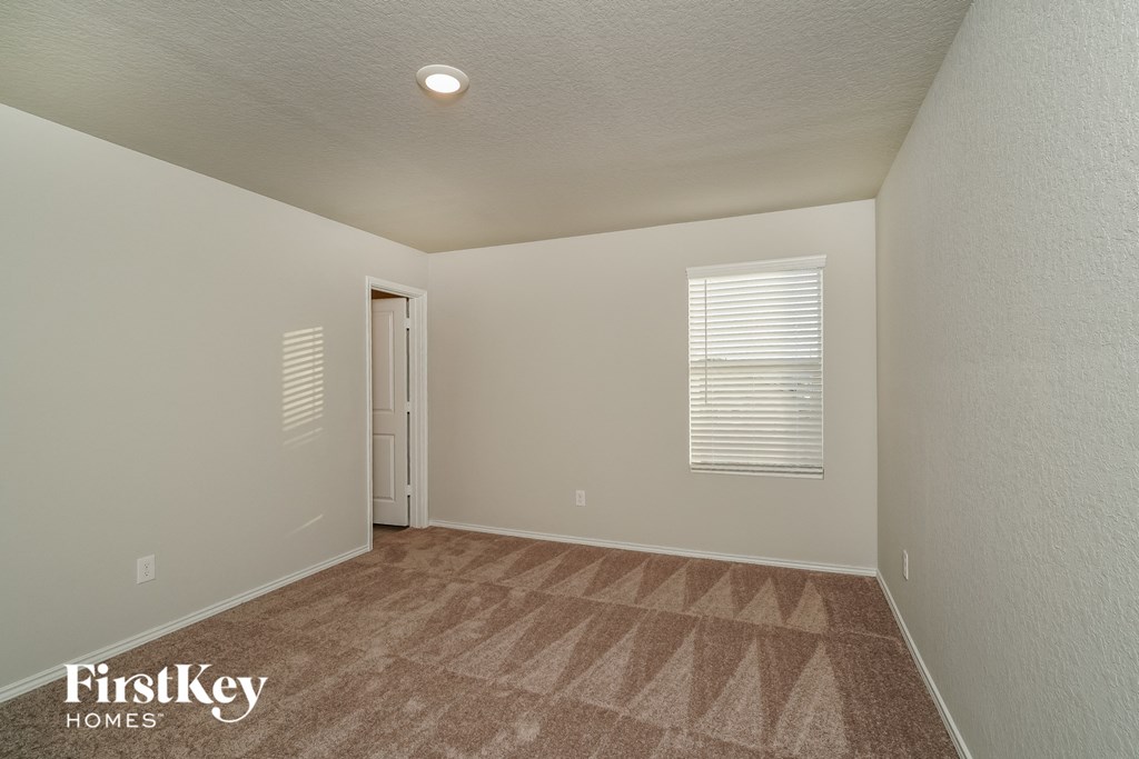 the upstairs bedroom with carpet and a door to the bathroom