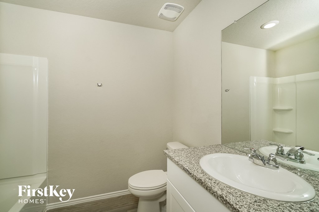 a bathroom with a sink toilet and a mirror