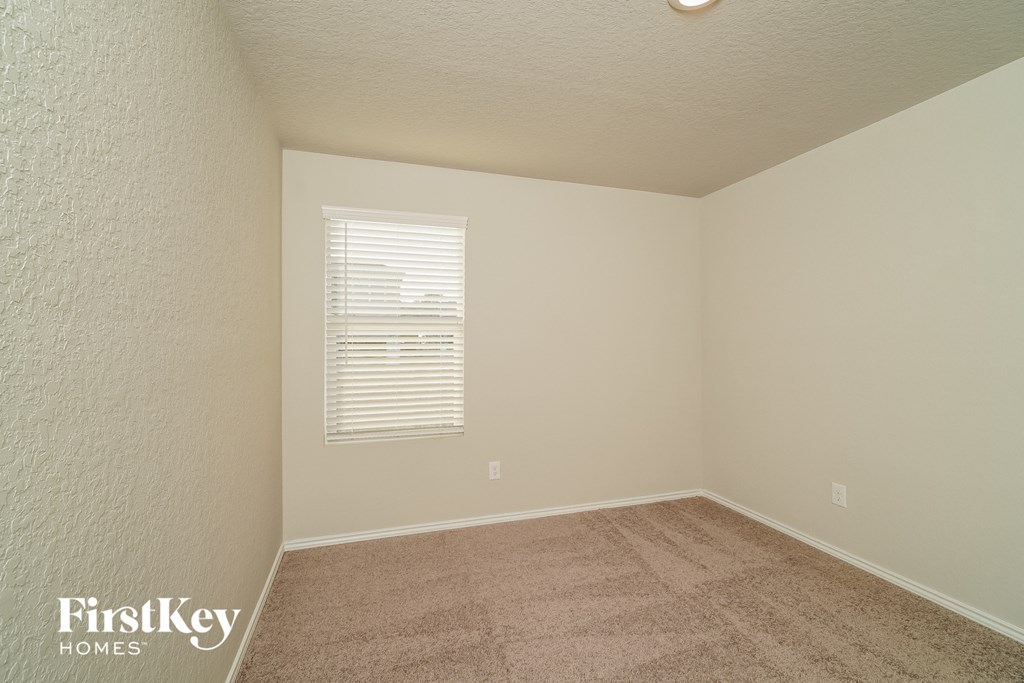 a empty room with a carpeted floor and a window