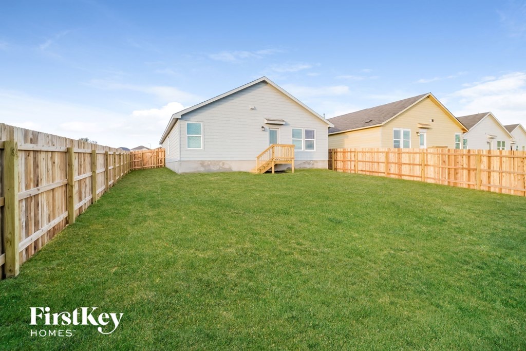 a fisheye lens view of a fenced in backyard with a house